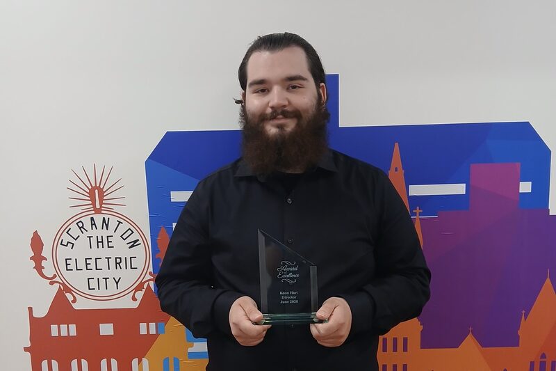 Keon Hart, Director at Keystone Client Solutions, holding his Award of Excellence